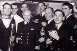 Christmas Day 1950. Electrical Senior Rates invited to the wardroom for drinks. Mr Wannicott clowning around, Moe Symons less jacket, Comdr. Elect with his relief Comdr Lock to Alan Clements' right, Barry Partridge and Bruce? Photo from Alan Clements