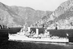 HMS Gambia, Flagship of Admiral Sir John Edelsten, C in C Mediterranean, entering Marmarice Harbour, Turkey, flying the flag of the C in C. Mediterranean fleet summer cruise, July 1950, and on the Greek island of Skiathos during an exercise known as "Bandit". Imperial War Museums A 31692A