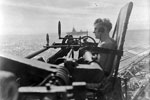 One of the pom-pom gun's crew on HMS Warspite, with HMS Formidable in the background. Force A's of the Eastern Fleet return to Kilindini from Colombo. 23 June-2 July 1942. Photo: Lt. D. C. Ouids. Imperial War Museums A 11002