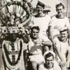 "The boys in Durban. Ian Boys is the centre one there, and that is the rickshaw puller. The natives down there doll up and they put all head dresses on and everything and they'd stand approximately nine and ten feet high, and bottle tops all round their ankles and they would get you in the rickshaw and away you'd go."