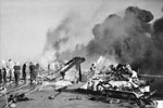 Firefighters busy on board HMS Formidable after a Japanese suicide plane had crashed on the flight deck. The flight deck is strewn with wreckage and black smoke is pouring from the still burning fires at the far end of the flight deck. HMS Formidable was hit by a Kamikaze on May 4 and again on May 9. Imperial War Museums A 29314