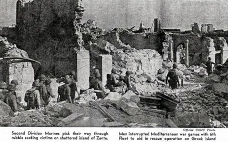Second Division Marines pick their way through rubble seeking victims on shattered island of Zante. Men interrupted war games with 6th Fleet to aid in rescue operation on Greek island