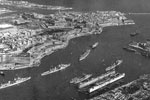 Grand Harbour, Valletta, Malta, 1955. Photo from Ray Holden. Ray sent me this photo in January 2002. He writes "The 1st Cruiser Squadron used to tie up on the far side. This picture was taken in 1955 when Sheffield was flagship, that's her second from left. The ship behind is Kenya, this is where Gambia used to tie up behind her flagship which was Liverpool."