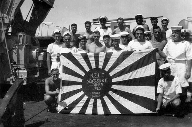 HMNZS Gambia's crew with a captured Japanese flag