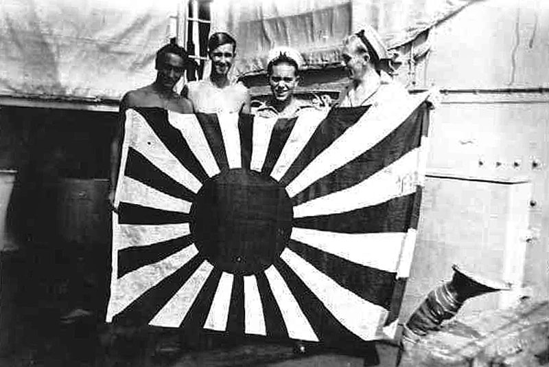 HMNZS Gambia's crew with a captured Japanese flag