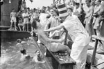 Crossing the Line on the troop transport SS Empress of Australia, on an African Troop Convoy, August 1941. The initiate being ducked by the 'bears' after being shaved by King Neptune's barber. Imperial War Museum A5176