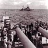 HMNZ Gambia seen above the big guns of HMS Howe near Auckland, New Zealand in January 1945. HMS Howe was the flagship of Admiral Bruce Fraser, CinC of the British Pacific Fleet. Imperial War Museums A 28854