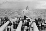HMNZ Gambia seen above the big guns of HMS Howe near Auckland, New Zealand in January 1945. HMS Howe was the flagship of Admiral Bruce Fraser, CinC of the British Pacific Fleet. Imperial War Museums A 28856