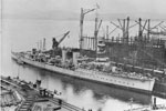 HMS Caradoc fitting out at Scotts, Grenock Yard in 1918. The submarine G14 is in the forground. HMS Caradoc, a C class cruiser, was launched in December 1916 and scrapped in April 1946. Imperial War Museums FL 7498