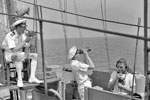 High up on the air defence platform in the cruiser HMS Edinburgh. The air defence officer is on the left, and passes orders through a loud speaker microphone. A midshipman in the centre watches through glasses for enemy aircraft, while the rating on the right passes orders for the gun's crew. August 1941. Photo: Lt. R. G. G. Coote. Imperial War Museum A 5019
