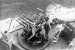 One of HMS Edinburgh's gun crews at their action stations, wearing 'scrum' caps to protect their ears from noise. August 1941. Photo: Lt. R. G. G. Coote. Imperial War Museum A 5022