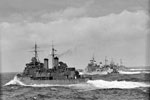 Escorting a convoy in the Mediterranean (Operation Halberd). The convoy got through to Malta after being attacked by three groups of enemy torpedo carrying aircraft heavily escorted by fighters in the central Mediterranean. 14 enemy aircraft were destroyed but HMS Nelson was damaged by an aerial torpedo. The escorting cruisers had a busy time, and are seen steaming fast to take up their positions. Left to right: HMS Edinburgh, HMS Sheffield, HMS Kenya. September 1941. Photo: Lt. R. G. G. Coote. Imperial War Museum A 5645