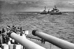 HMS Gambia seen above the big guns of HMS Howe in New Zealand waters, January 1945. Imperial War Museums A 28855