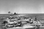 HMS Valiant during a 15" practice shoot from HMS Illustrious, in the Indiana Ocean on December 22, 1942. The planes in the foreground are Fairey Fulmars of 806 Squadron, Fleet Air Arm. Photo: Lt. D. C. Oulds. Imperial War Museums A 15152