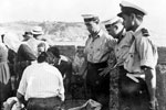 Officer and ratings from HMS Gambia ashore in Cephaplonia issuing water to the population, August 1953. Image from Imperial War Museums, A32646
